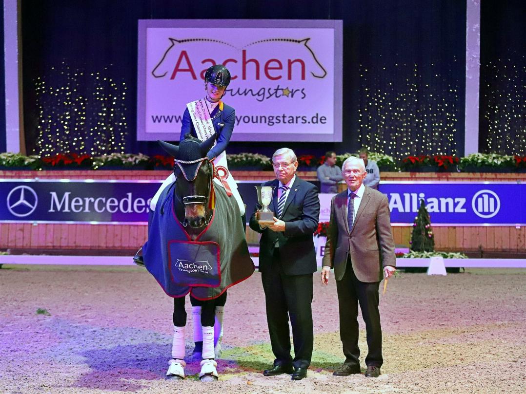 Kimberly Pap (NED) is pleased to receive the trophy and congratulations from Klaus Peters and ALRV President Carl Meulenbergh. Photo: Alexander Marx.